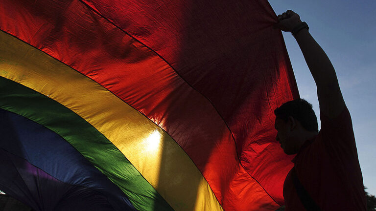A gay rights activist holds a rainbow flag during a rally to mark the International Day Against Homophobia in Managua