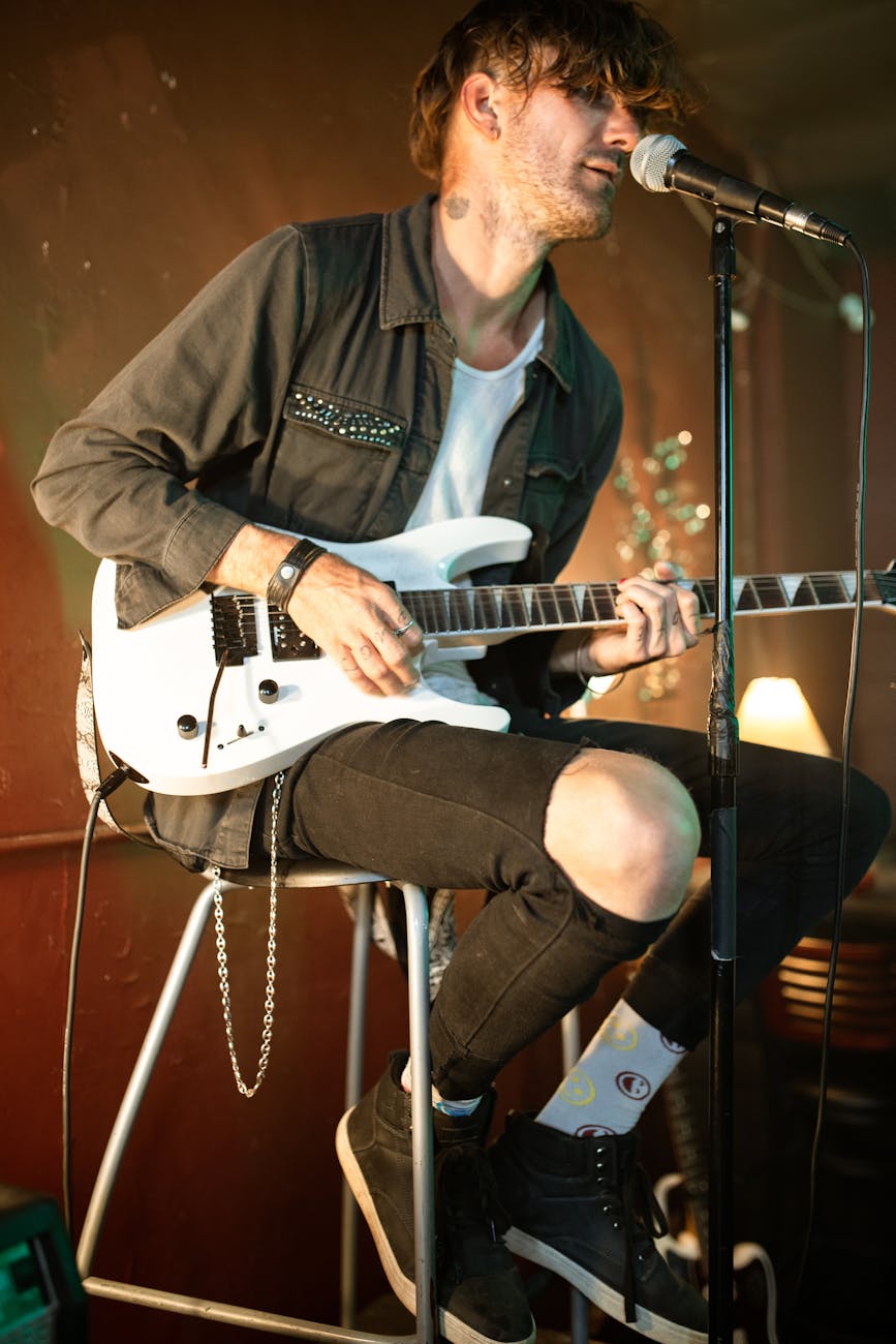 man in black jacket playing electric guitar