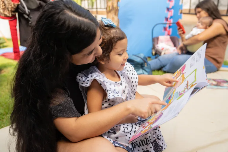 MÃE E FILHO LENDO LIVRO NO projeto literário do Meninas de Luz